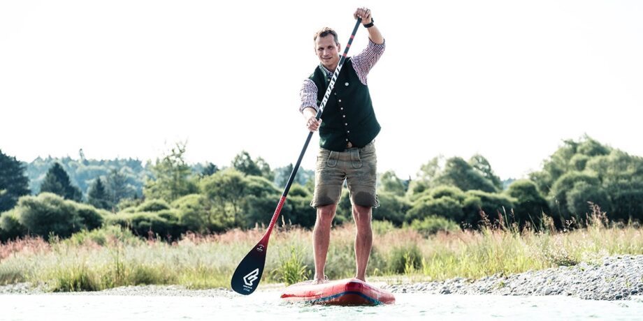 Pascal auf seinem SUP in Lederhosen und seiner Garmin Uhr
